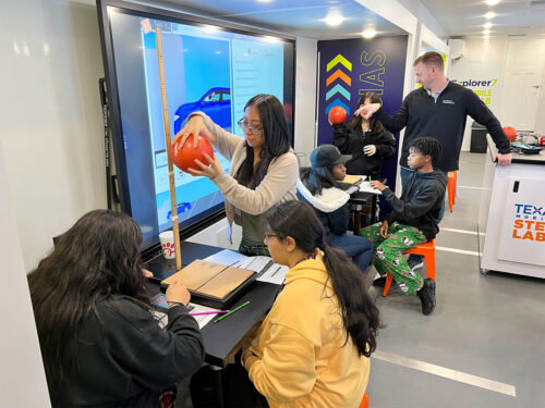 teacher helps students in the texas mobile stem lab