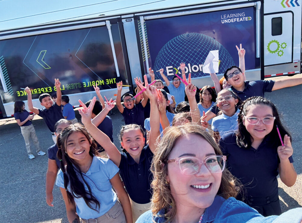 students and maria gonzales in front of the explorer lab