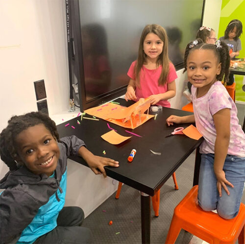 first graders work happily in the learning undefeated lab on engineering design challenge