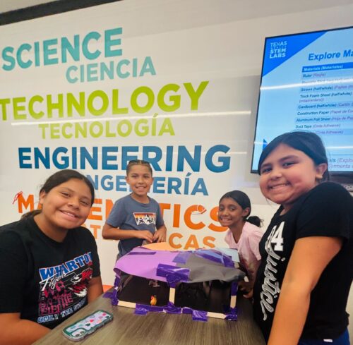 students in front of science mural wall